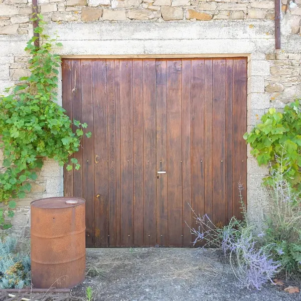 Porte de garage en bois rénovée avec soin et précision.