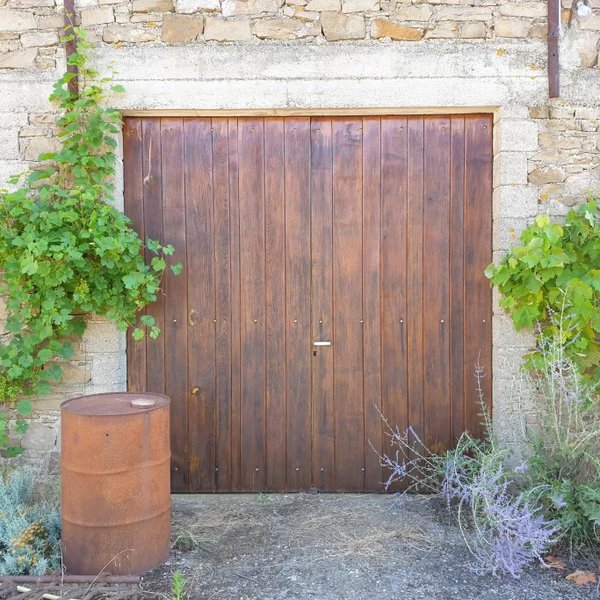 Porte de garage en bois rénovée avec soin et précision.